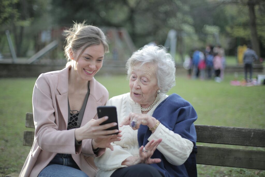 A woman showing the recallify productivity app on her smartphone to another woman