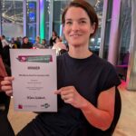 A woman showing her winning certificate