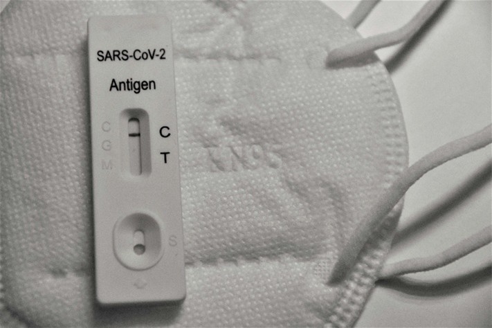 A SARS CoV 2 antigen test resting on a KN95 face mask