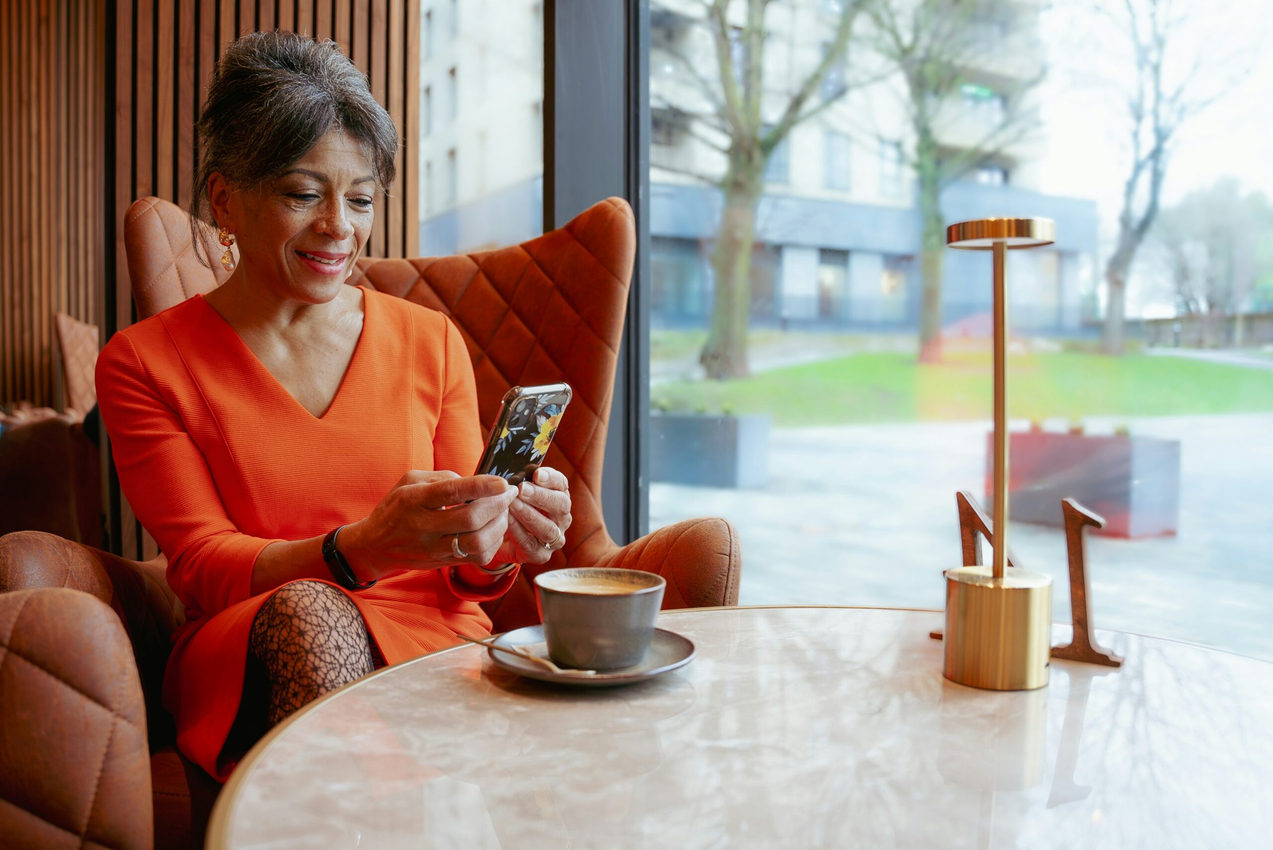 Woman building habits with Recallify, checking her phone with a cup of coffee