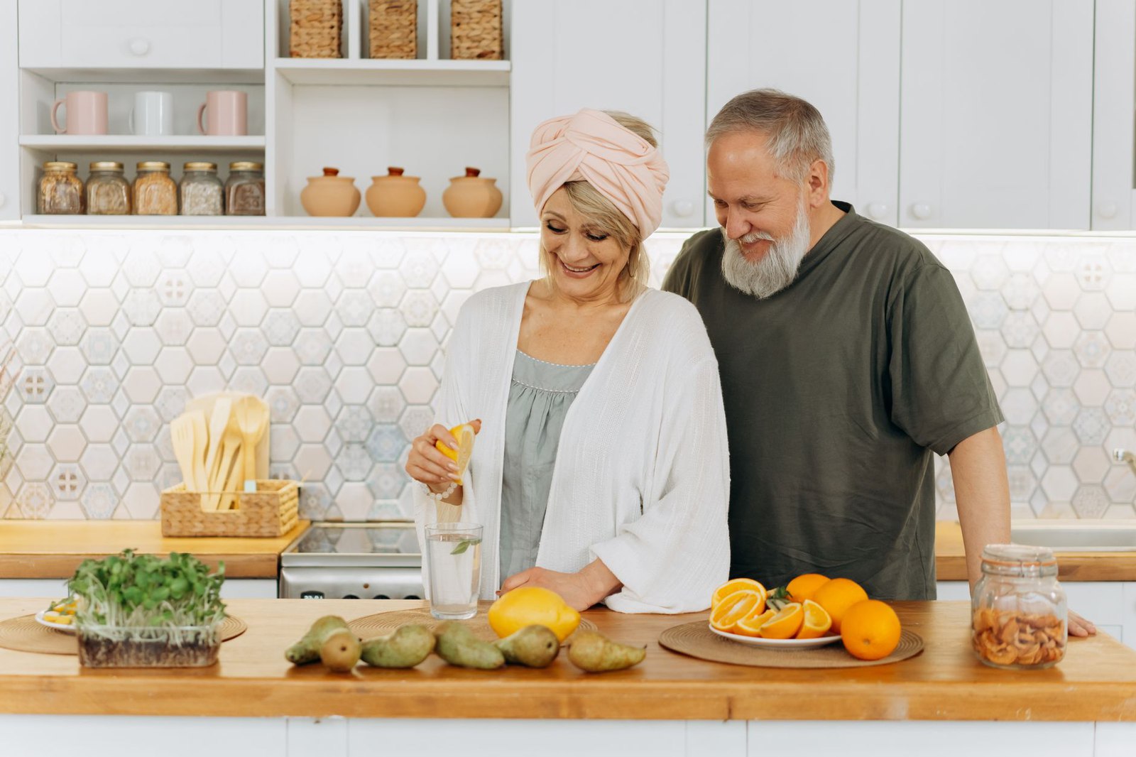 An older couple preparing food together in a bright kitchen