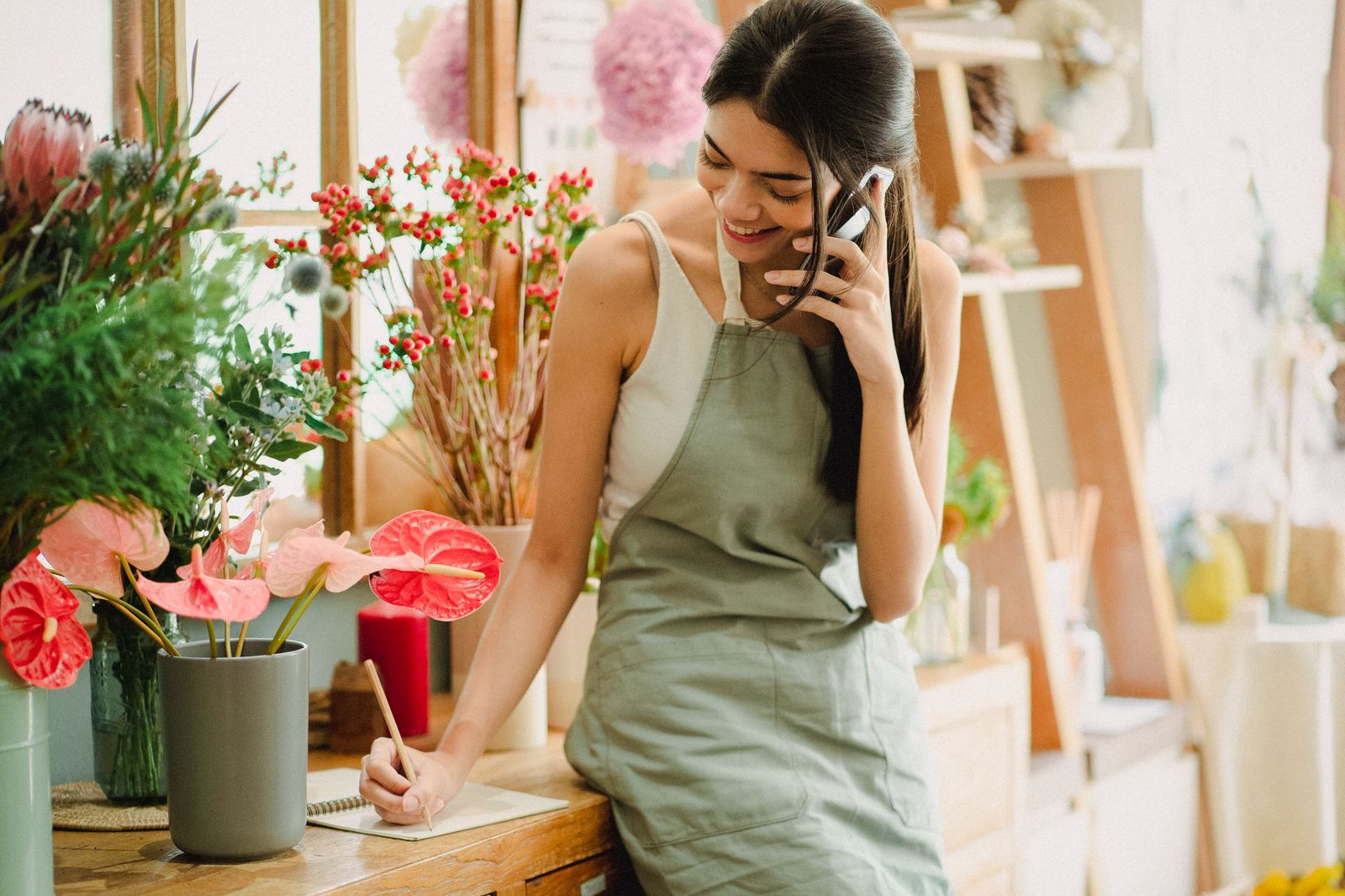 Access to Work for self-employed people: a florist taking a customer call in her shop and writing down the order